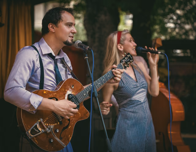 Gitarist i pjevačica u duetu, svaki uz svoj mikrofon